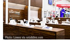 The b8ta store-within-a-store displays are located near the front of Lowe’s stores and feature wood-paneled aisles where shoppers can find more than 60 smart home products, including security systems, thermostats, cameras, lighting, speakers and more. | Photo: Lowes via retaildive.com